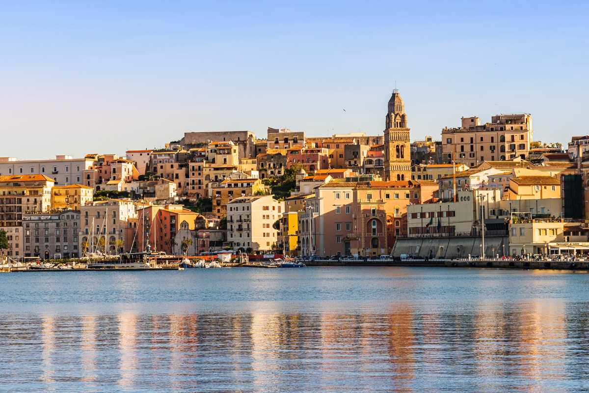 Scorcio panoramico di Monte Orlando al tramonto, vista su Gaeta e il mare. Cielo limpido, vegetazione mediterranea, sentiero ben visibile.