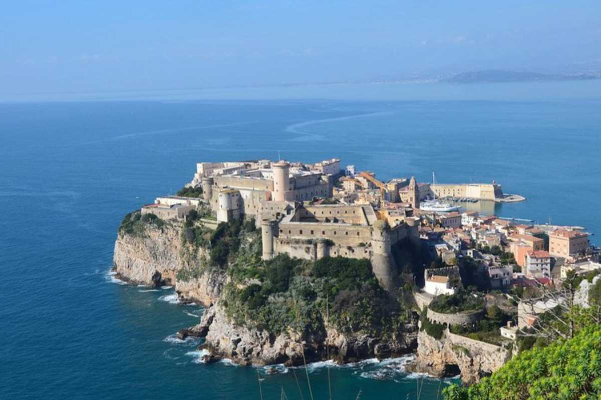 Panorama dall’alto di Gaeta: centro storico sul promontorio, spiagge dorate, mare turchese e Montagna Spaccata al tramonto. Atmosfera mediterranea.