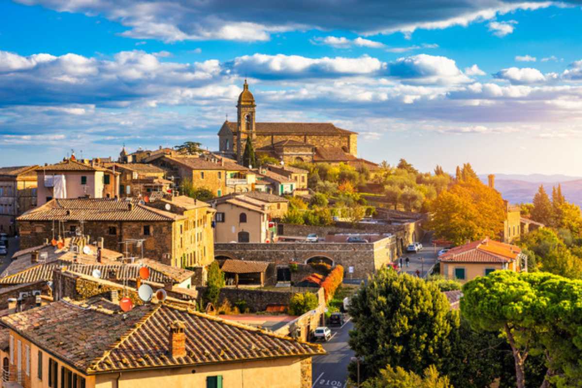 Dettaglio della spiaggia di Serapo affollata, acqua turchese, promontorio di Monte Orlando sullo sfondo, famiglie e bagnanti rilassati.